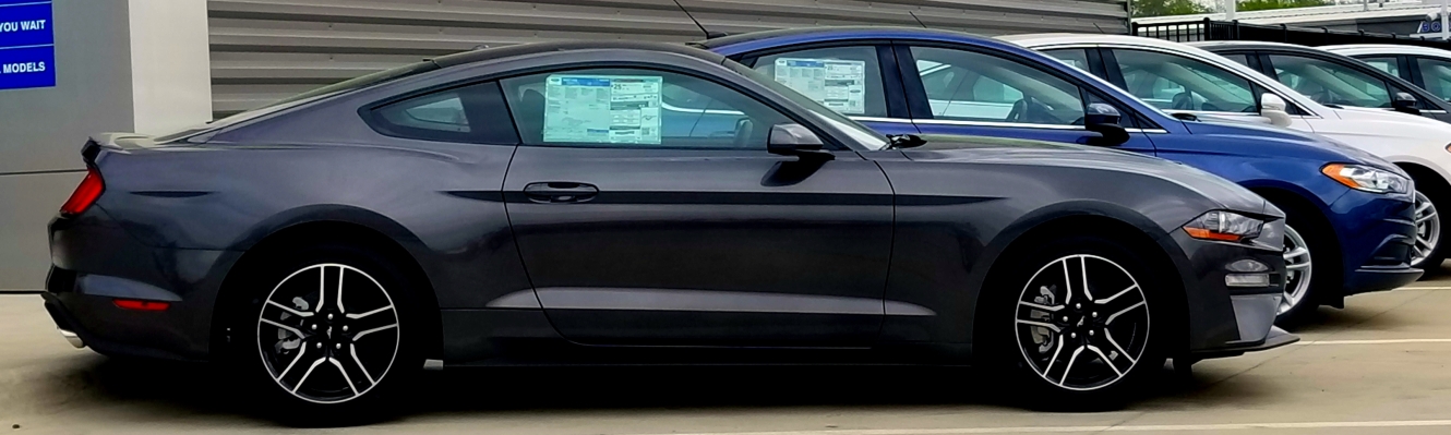 Row of new cars at a dealership.